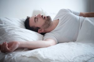 man snoring loudly in bed